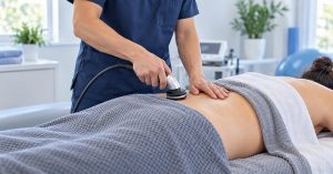 Clinician performing TECAR therapy on a patient's lower back